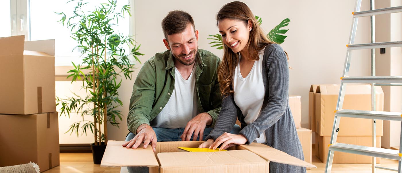 Couple unpacking moving boxes after a home inspection 